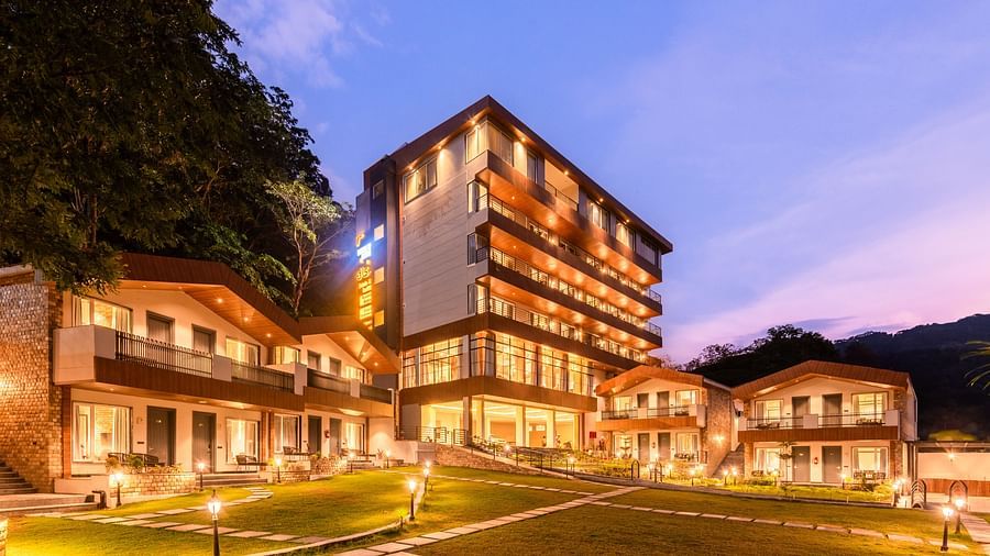 Exterior facade view of DLS Divine River Resort and Spa with warm lighting and garden area taken in the evening 